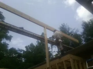 Carpenter setting a ridge beam over a new addition frame — Ice Dam Removal by Roofing Brothers in Nicollet