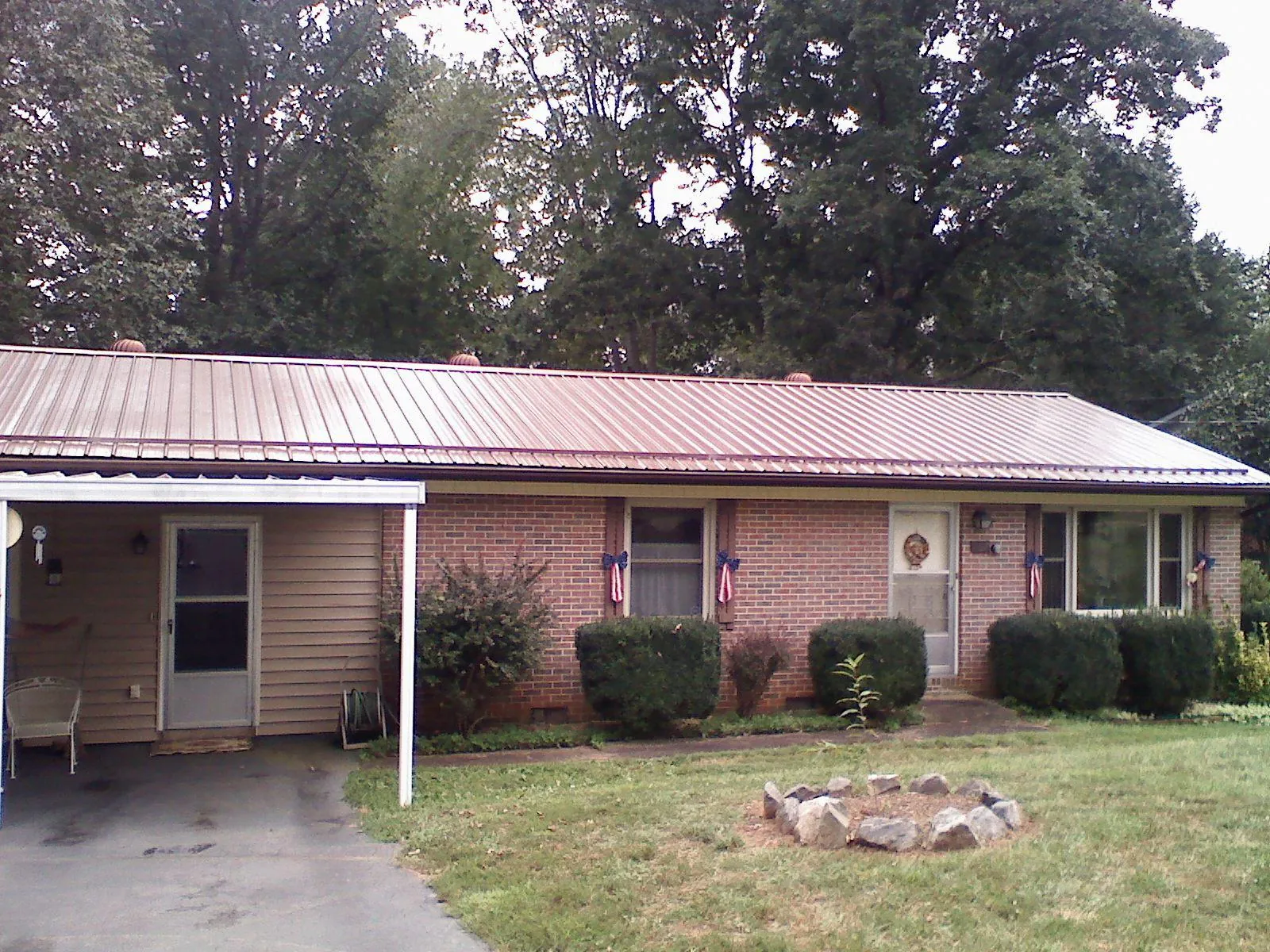 Bronze metal roof and carport on a brick ranch home — Roof Repair work by our crew in Nicollet